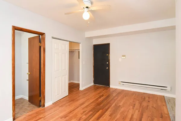 a view of empty room with wooden floor