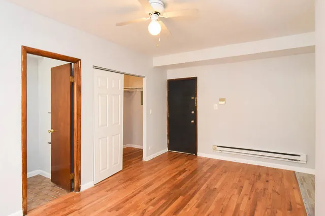 a view of empty room with wooden floor