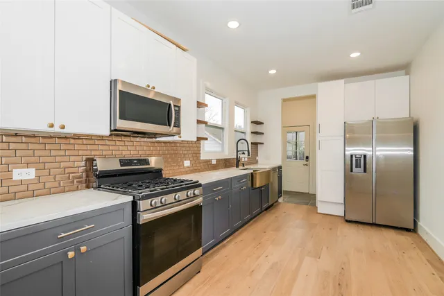 a kitchen with stainless steel appliances granite countertop a stove a sink and a refrigerator