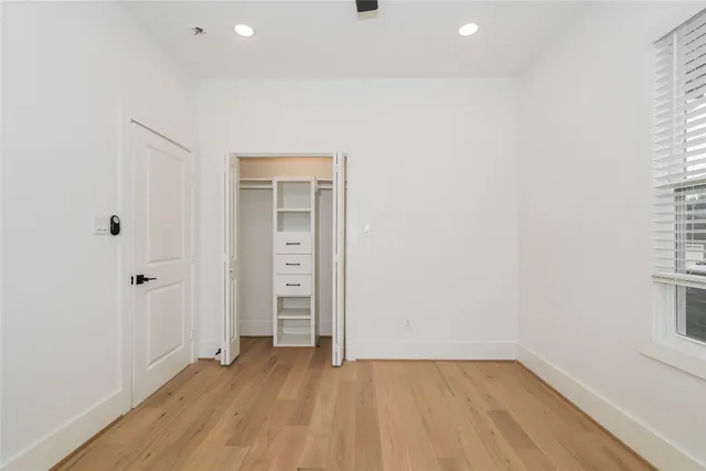 an empty room with closet and windows
