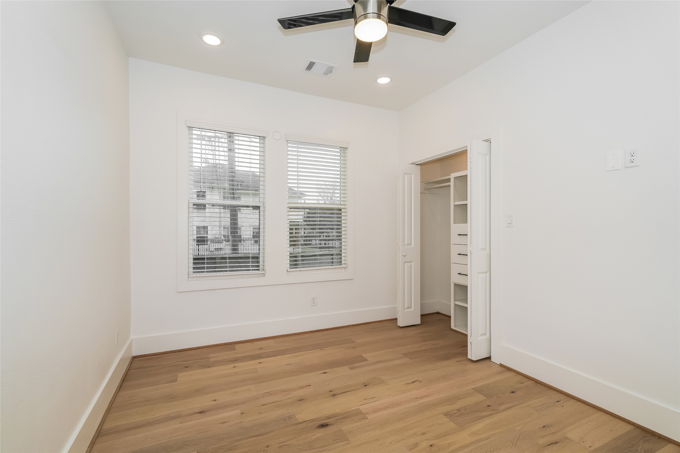 231 Grace Street Houston, TX 77003 - Photo 10 of 15 an empty room with wooden floor fan and windows