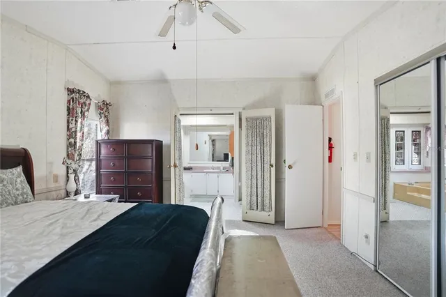 a bedroom with a bed and dresser with mirror