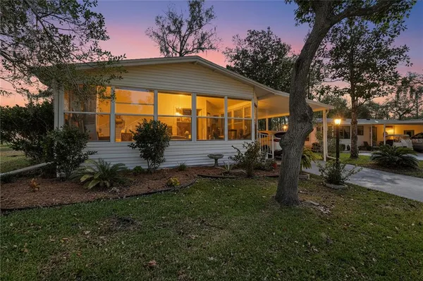 a view of a house with backyard and sitting area