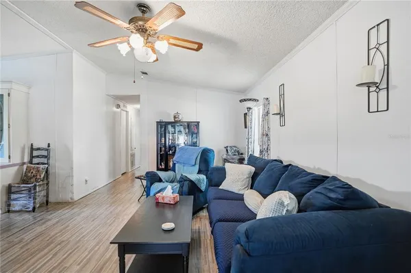 a living room with furniture kitchen view and a chandelier