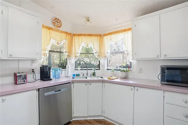 a kitchen with a sink window and cabinets