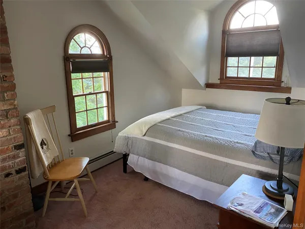 a bedroom with a bed chair and a window
