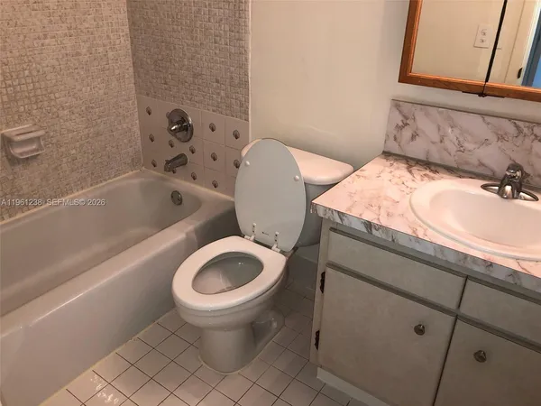a bathroom with a granite countertop toilet a sink and a bathtub