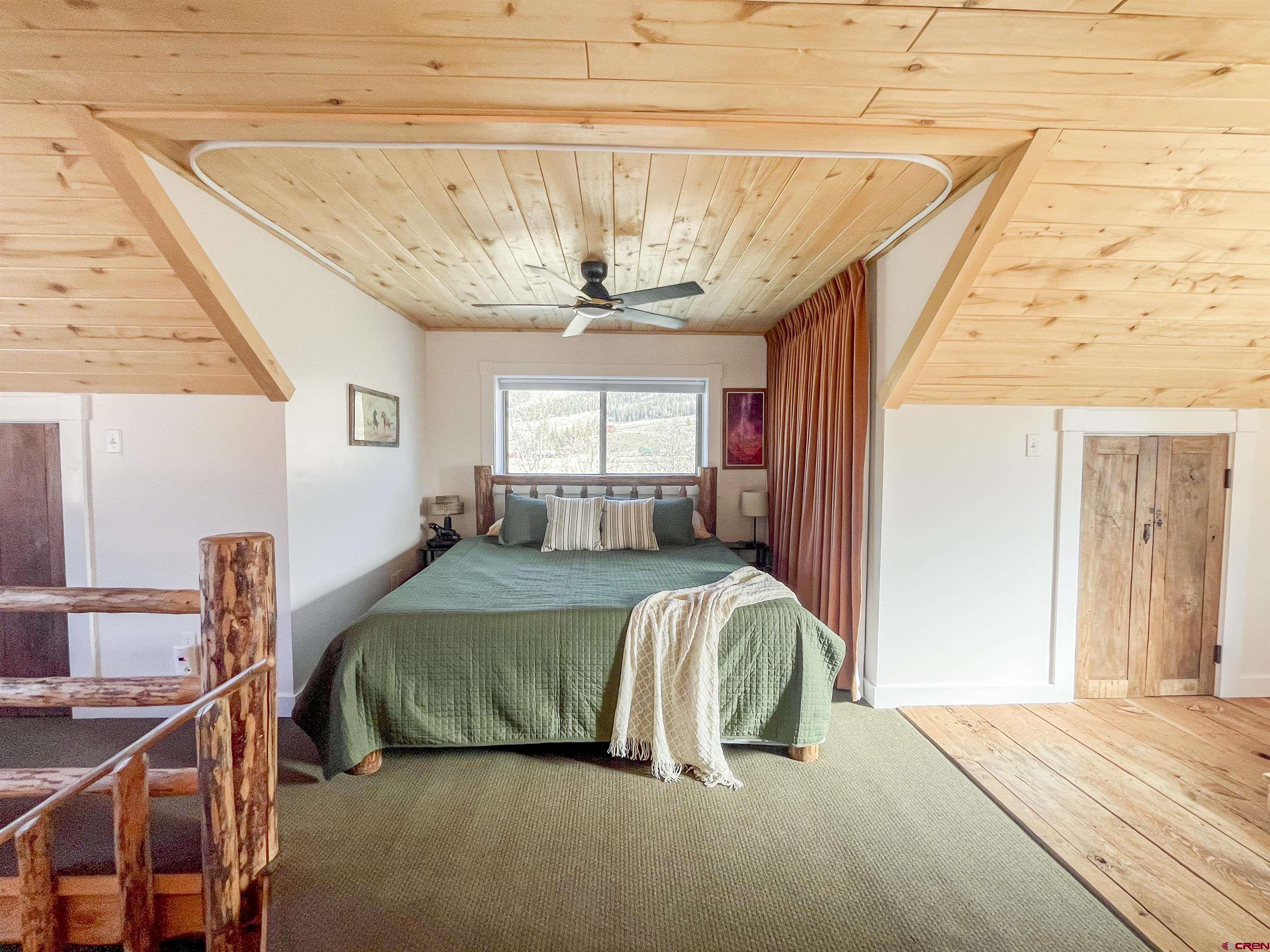 148 Rio Grande Drive Creede, CO 81130 - Photo 25 of 38 a bedroom with a bed and a chandelier