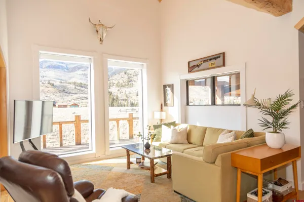 a living room with furniture and floor to ceiling windows