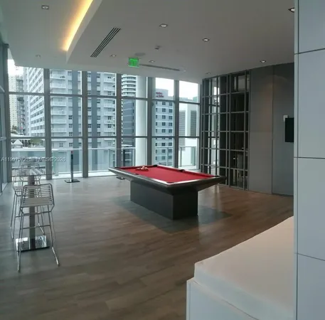 a living room with fireplace furniture and floor to ceiling windows