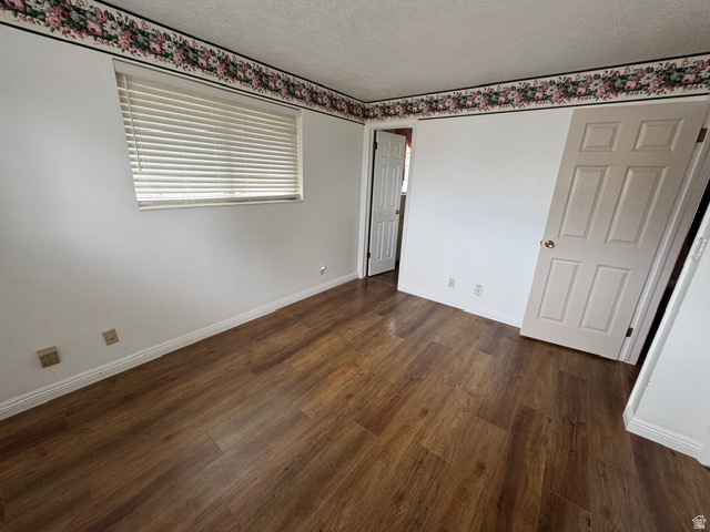 588 North 4500 West West Point, UT 84015 - Photo 20 of 61 Unfurnished bedroom with a textured ceiling and dark wood-style laminate floors