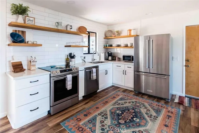 a kitchen with stainless steel appliances a stove a sink and a refrigerator