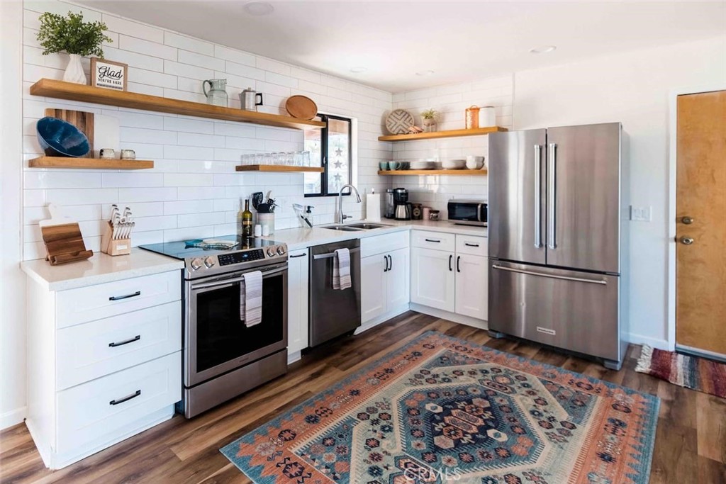 61029 Navajo Trail Joshua Tree, CA 92252 - Photo 13 of 41 a kitchen with stainless steel appliances a stove a sink and a refrigerator