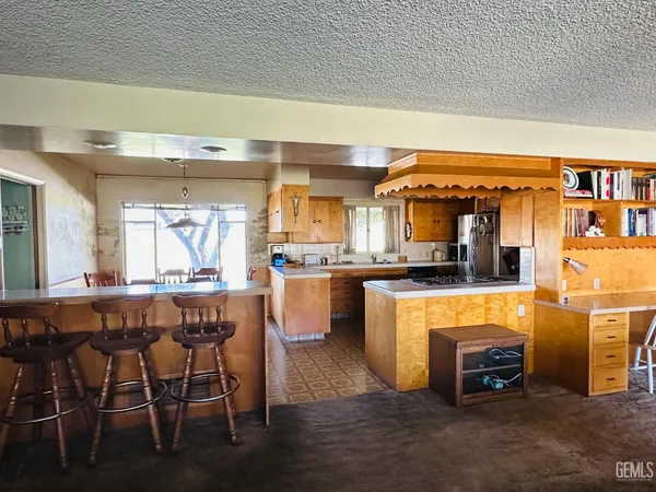 a kitchen with stainless steel appliances granite countertop a table and chairs