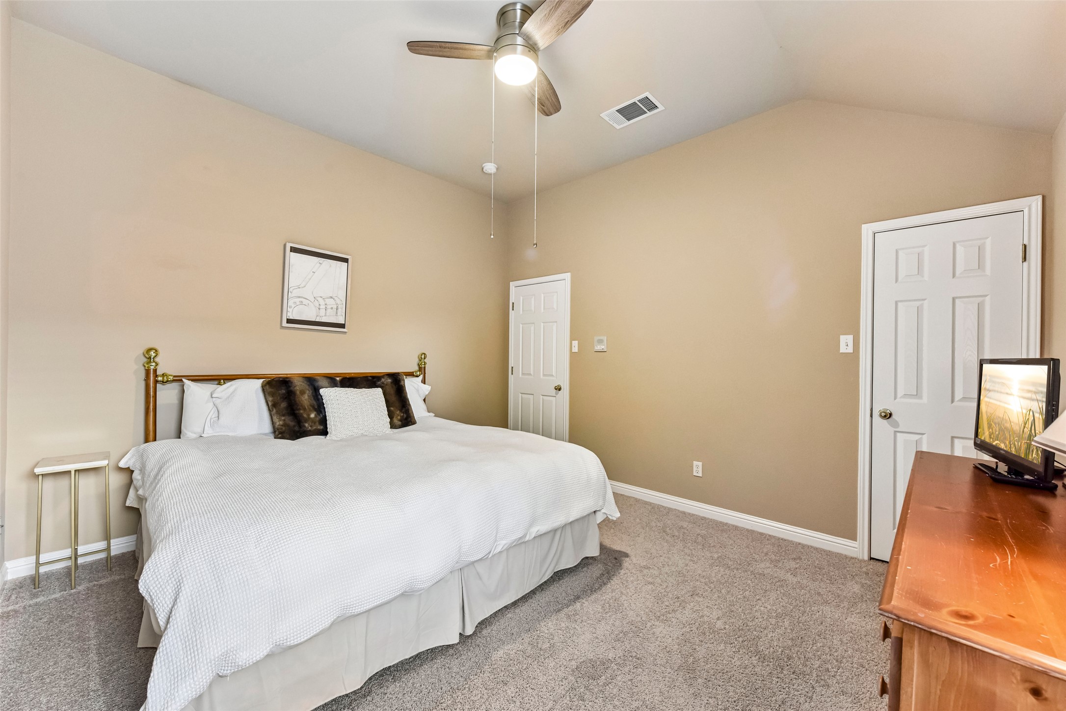 10216 Anahuac Trail Austin, TX 78747 - Photo 33 of 39 a bedroom with a bed and a flat tv screen on a dresser