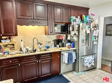 a kitchen with stainless steel appliances granite countertop a refrigerator and a sink