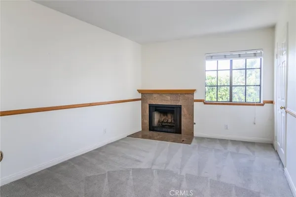 an empty room with a fireplace and window