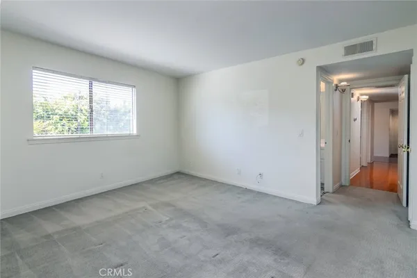 an empty room with windows and closet