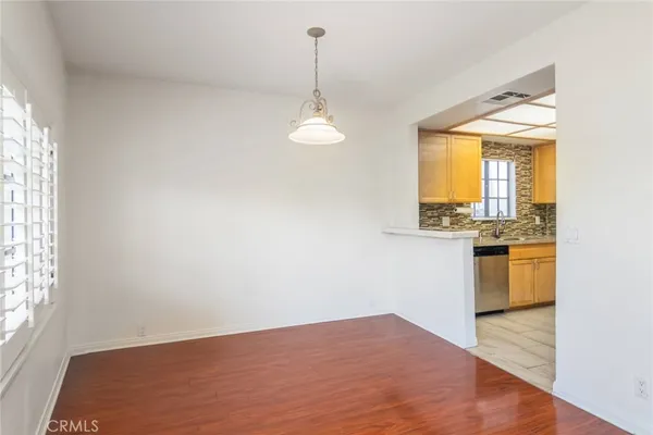 a view of a room with wooden floor and a ceiling fan