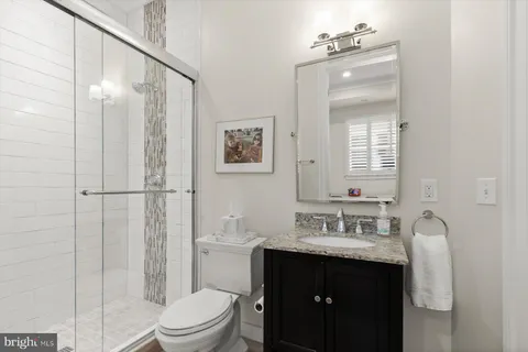 a bathroom with a sink vanity mirror and toilet