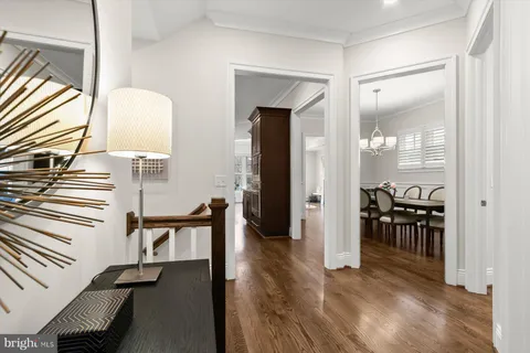 a view of a hallway with furniture and wooden floor