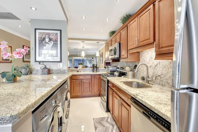 a kitchen with stainless steel appliances granite countertop a sink stove and cabinets