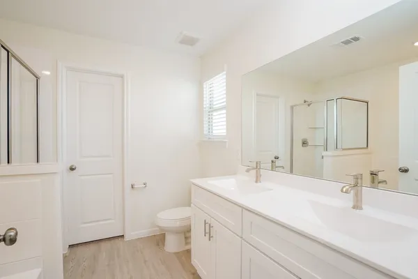 a bathroom with a bathtub a sink a vanity and a shower