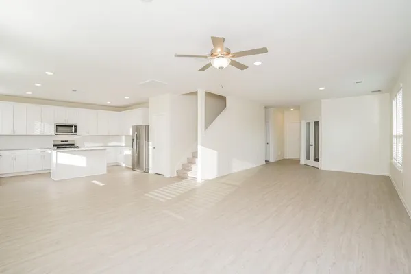 a kitchen with stainless steel appliances a refrigerator sink and white cabinets