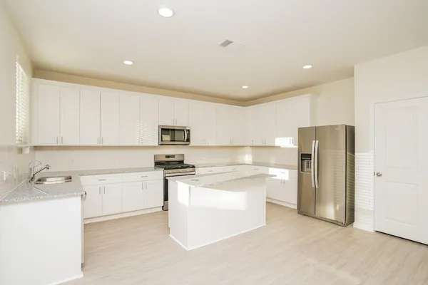 a kitchen with stainless steel appliances a stove refrigerator sink and cabinets