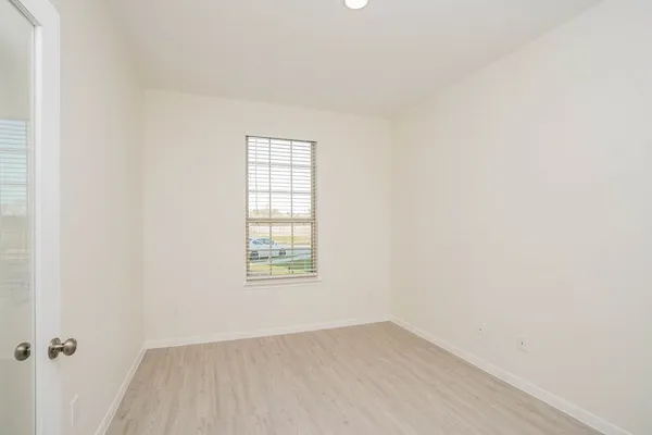 an empty room with a window and a fan