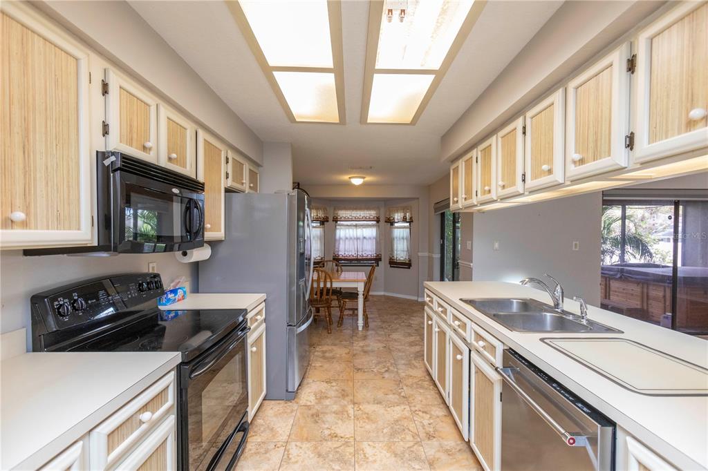 5701 Mossberg Drive New Port Richey, FL 34655 - Photo 5 of 58 a kitchen with stainless steel appliances granite countertop a sink stove and cabinets