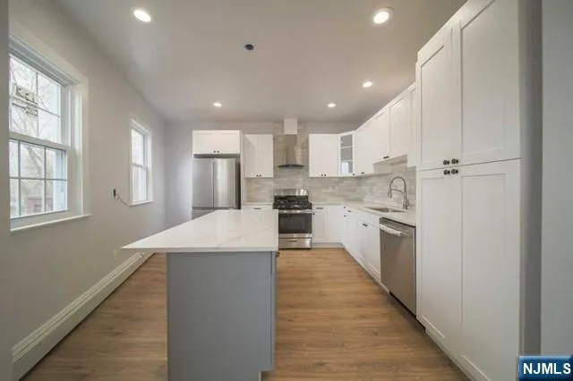 a large kitchen with stainless steel appliances kitchen island a large counter top and a sink