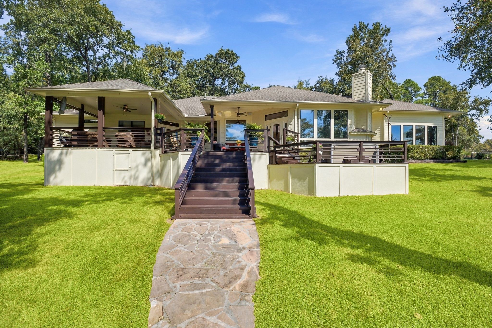 20341 Bay Hill Road Point Blank, TX 77364 - Photo 36 of 50 Impressive home with a stylish wrap-around deck, set amidst lush greenery, perfect for outdoor entertaining.