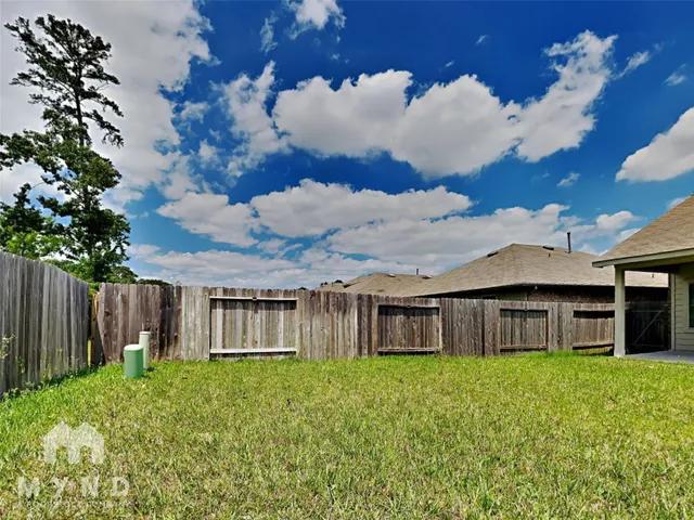 a view of a backyard with a barbeque and wooden fence