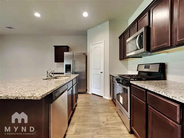 a kitchen with stainless steel appliances granite countertop a stove and a sink