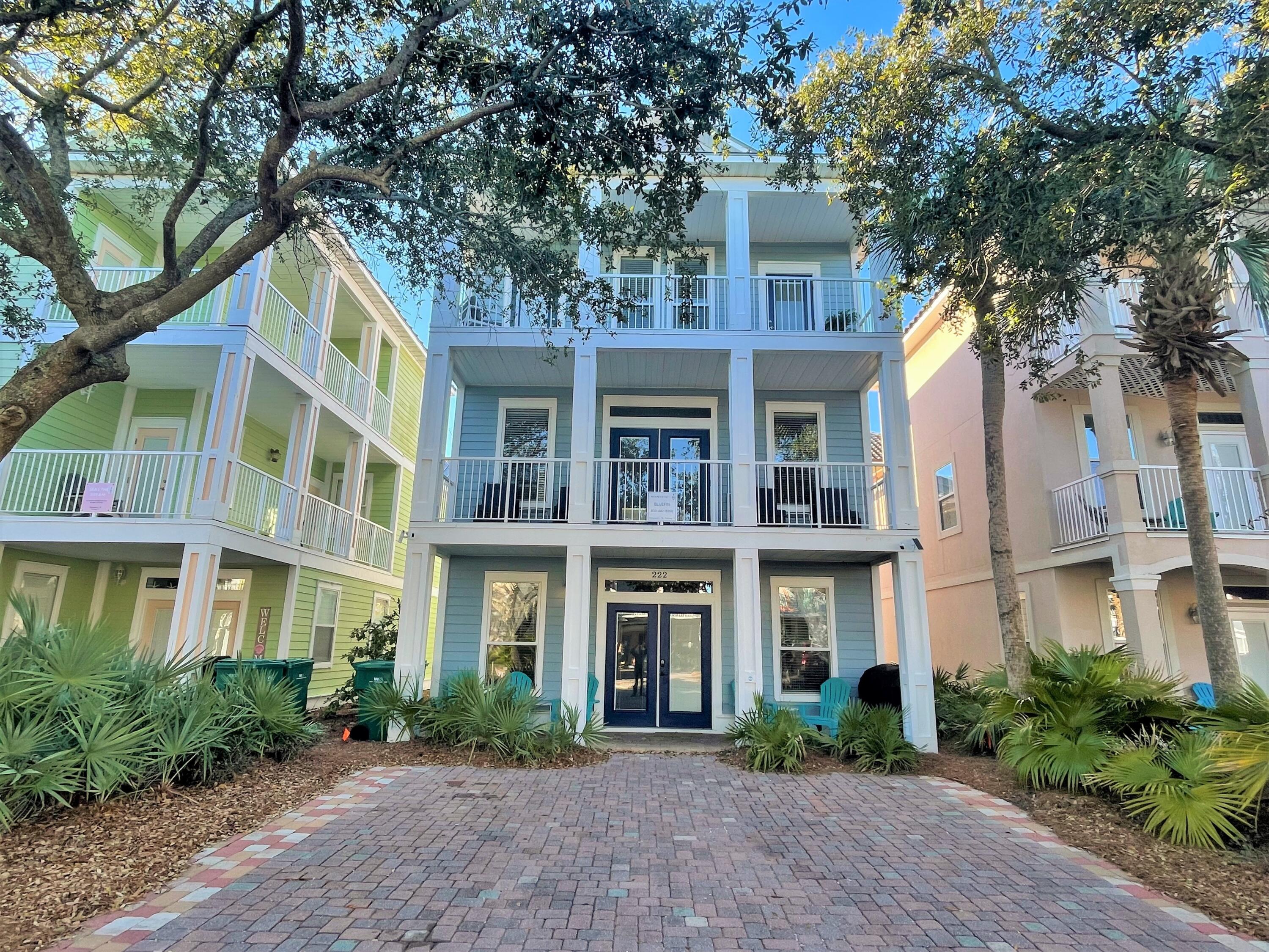 a front view of a residential apartment building with a yard and potted plants