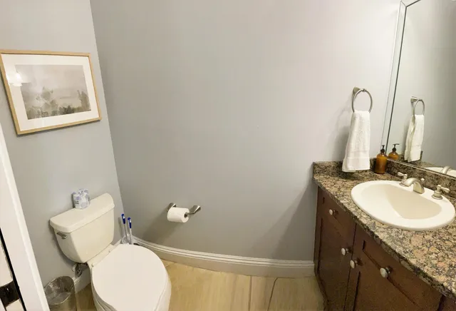 a bathroom with a granite countertop sink and a mirror