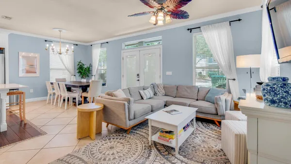 a living room with furniture a chandelier and a window