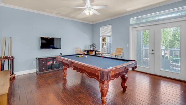a room with wooden floors and pool table