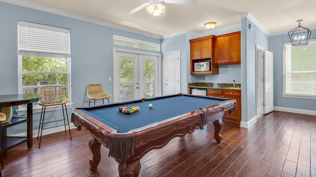 a living room with furniture pool table and windows