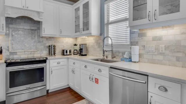 a kitchen with granite countertop white cabinets white stainless steel appliances and sink