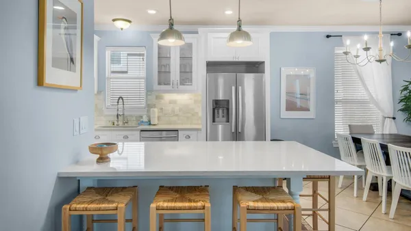 a kitchen with stainless steel appliances a dining table chairs and chandelier