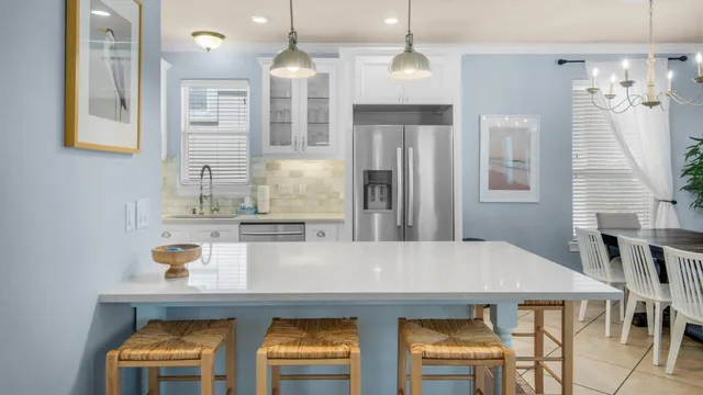 a kitchen with stainless steel appliances a dining table chairs and chandelier