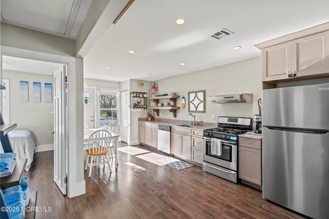 a bedroom with a bed and a table lamp on dresser