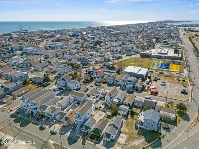 an aerial view of a city with lots of residential buildings and ocean view