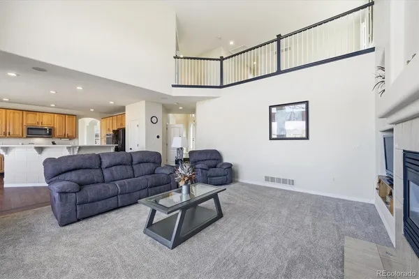 a living room with furniture and a view of kitchen