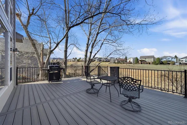 a view of chairs on deck with wooden floor and fence