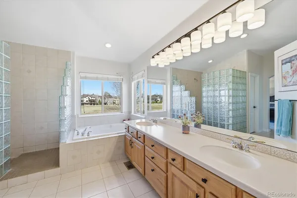 a spacious bathroom with a double vanity sink a mirror and a bathtub