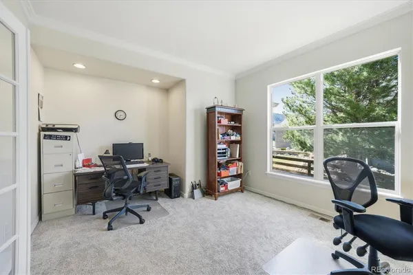 a view of a workspace with furniture and a window