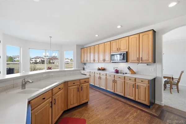 a large kitchen with a lot of counter space and wooden floor